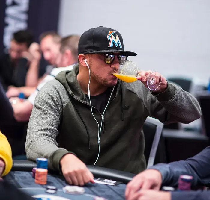 Poker player drinking orange juice at the table