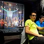 Antonio Esfandiari sitting beneath the photo of him from The Big One for One Drop