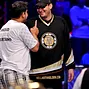 Owais Ahmed shakes talks to Phil Hellmuth after being eliminated.