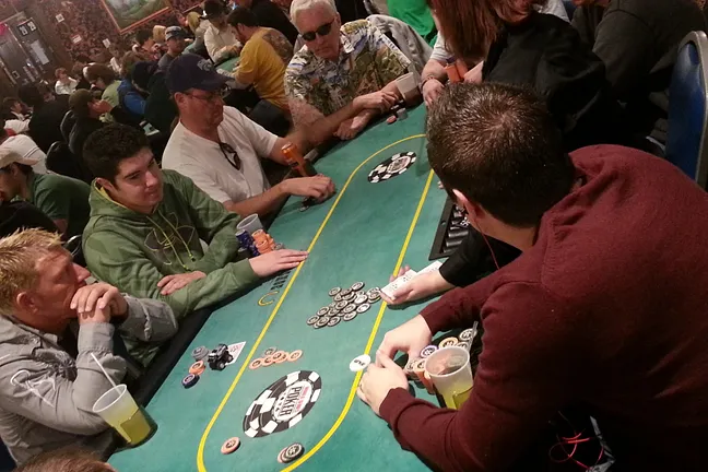 Blair Hinkle (green hoodie) watched as his brother Grant (maroon shirt) plays a hand.