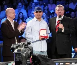 Steve Lipscomb (left) and Mike Sexton (right) award J.C. Tran an Omega watch for winning the Season 5 WPT Player of the Year