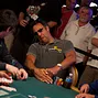 Brad Garrett strains his next to see his cards, then shows them to the rail prior to folding.