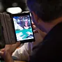Matt Glantz takes a photo of Phil Hellmuth on his iPad Mini