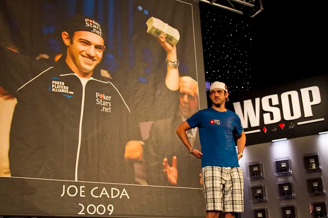 Campeão das WSOP Main Event 2010 Joe Cada em frente ao seu banner
