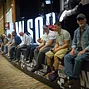 People hanging on the rail of the WSOP sign in the Pavilion Room